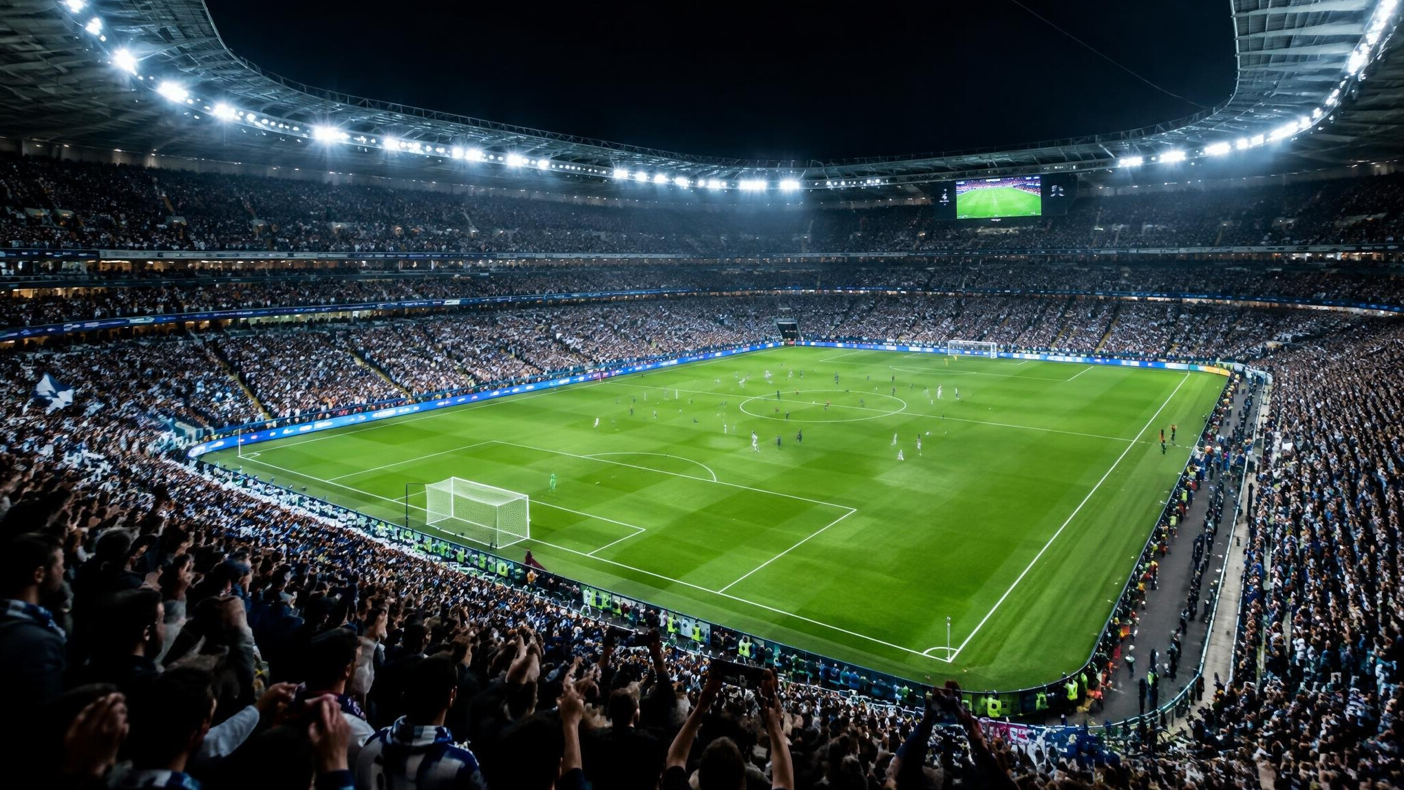 Football stadium filled with cheering fans at night